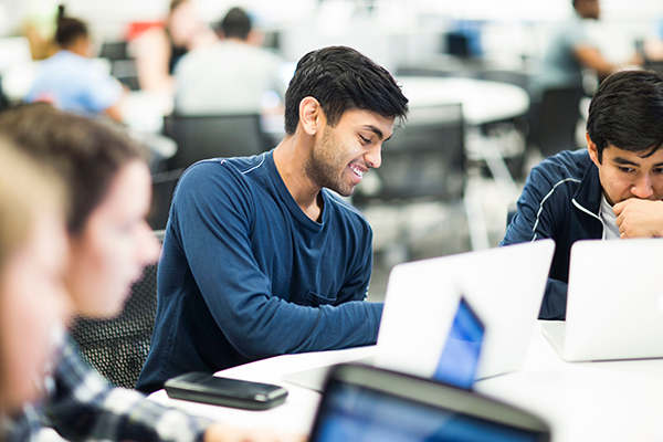 student-smiling-behind-computer.jpg